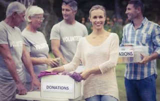 Picture of woman holding a box labeled with a donation sign | Miedema's Board Consulting Toronto