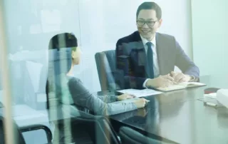 Meeting behild a closed glass door between a male and female colleague - Miedema's Board Consulting Toronto